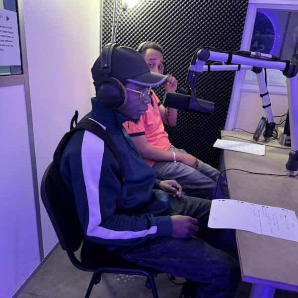 Deux jeunes hommes sont dans le studio de Radio Campus Angers, chacun face à un micro, casque sur les oreilles.