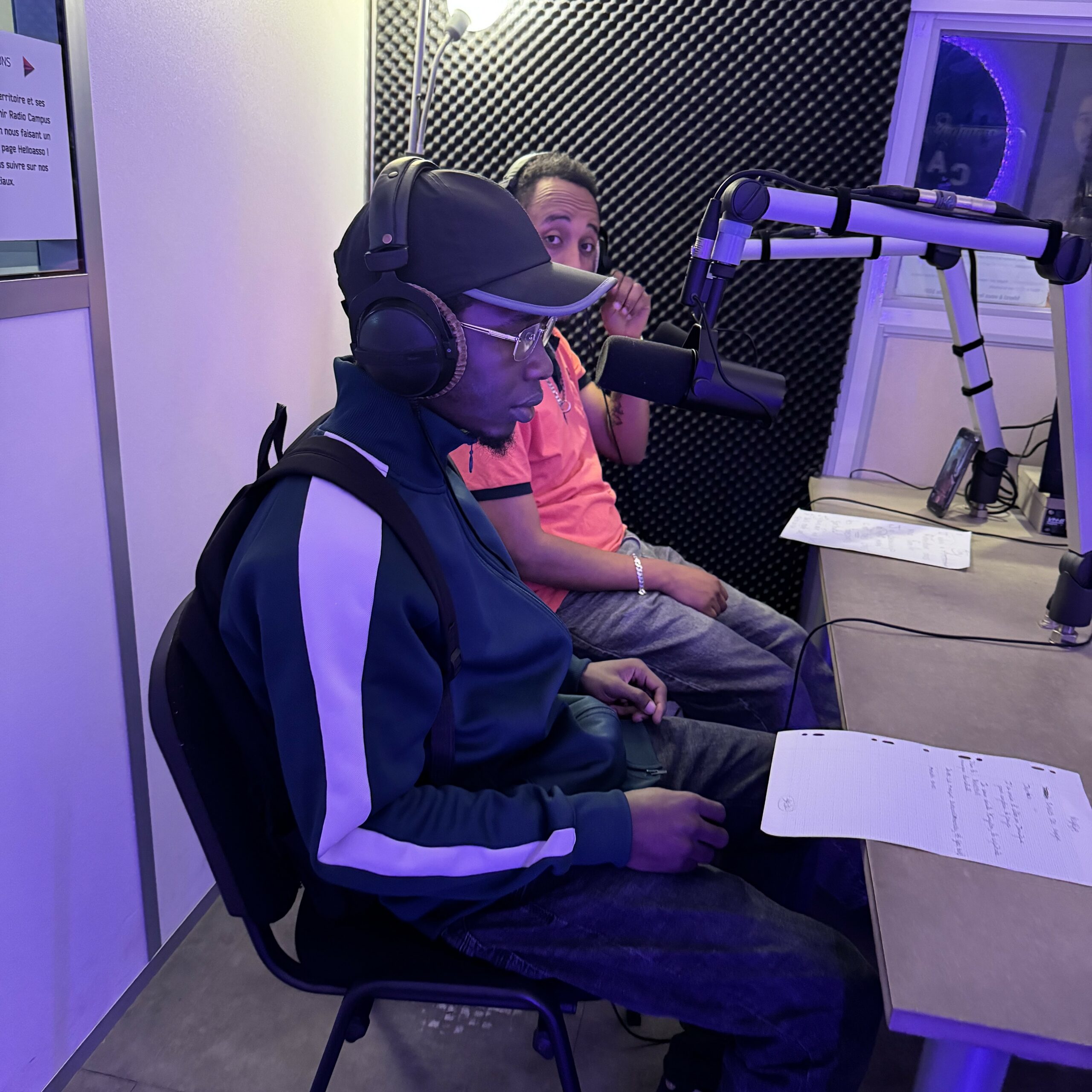 Deux jeunes hommes sont dans le studio de Radio Campus Angers, chacun face à un micro, casque sur les oreilles.